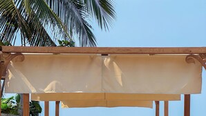 A beachside lounge with wooden benches and a canopy, overlooking the sea. - Santhiya Koh Chang Resort (Ko Chang)