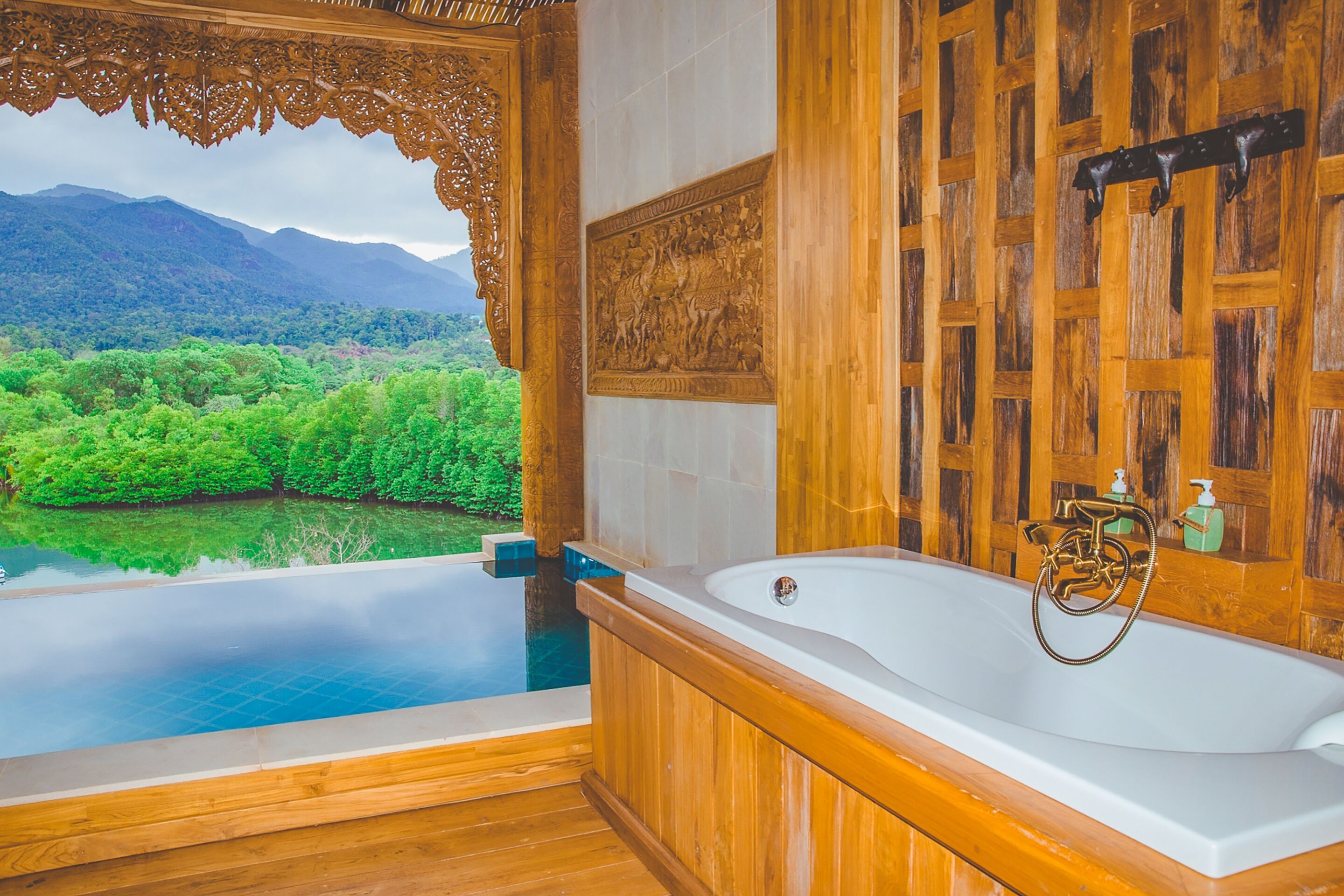 Una bañera de madera con vistas a una montaña y un bosque.
