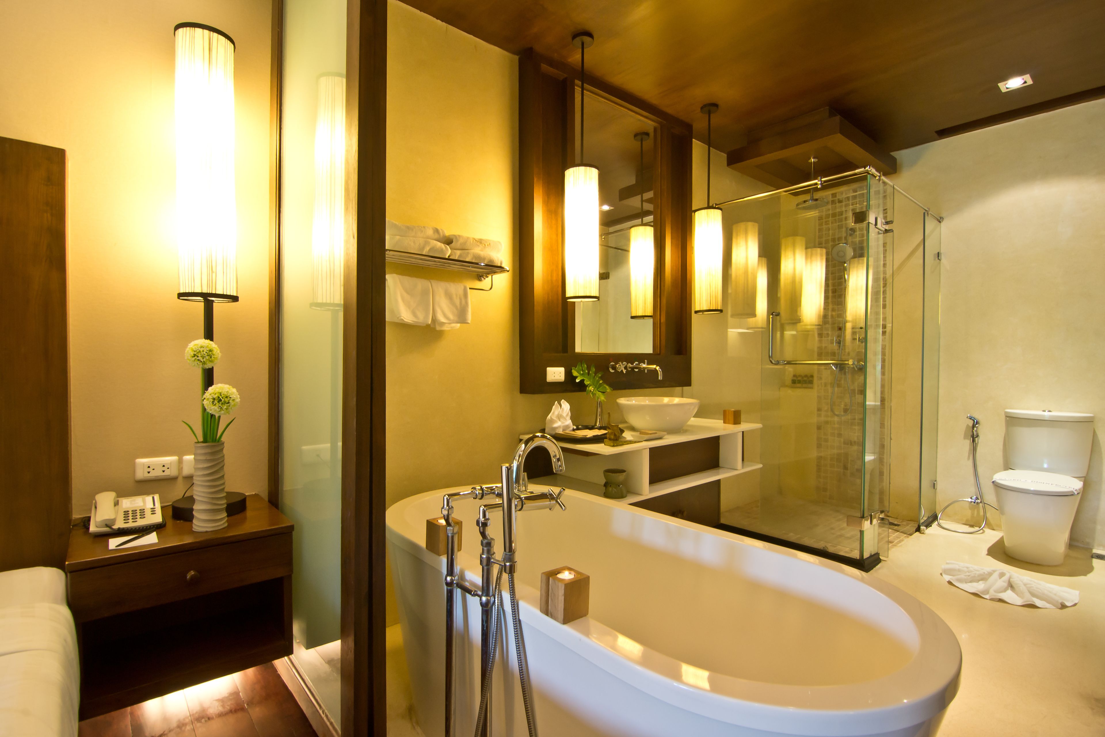 Un baño moderno con una bañera independiente, una ducha con cerramiento de vidrio y un espejo grande sobre el lavabo.