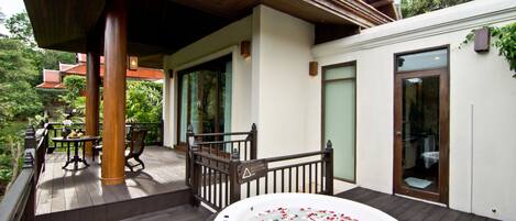 A spa area with a hot tub surrounded by wooden deck and outdoor furniture.