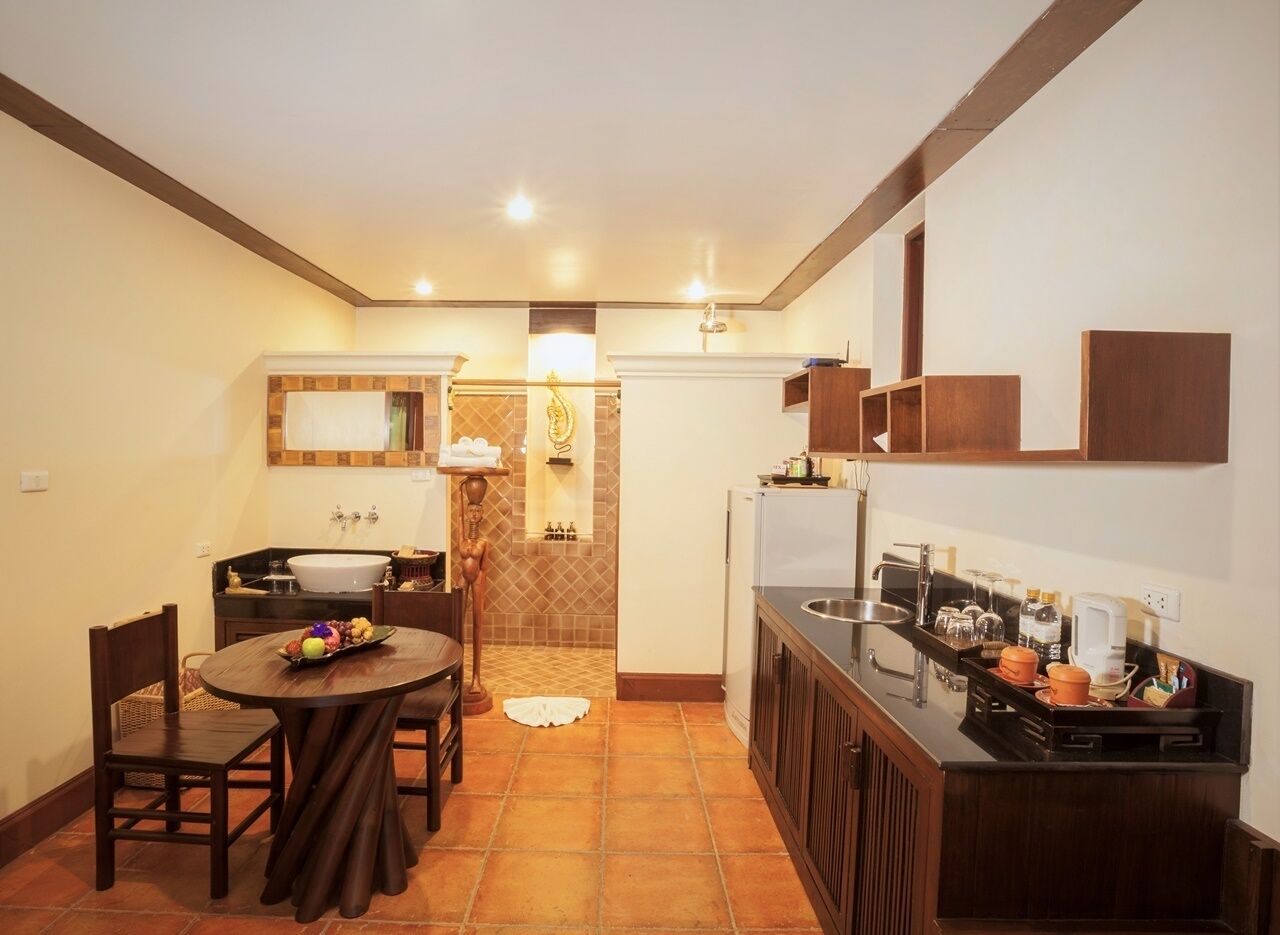 A compact kitchen with a dining area, featuring a sink, stove, and cabinets.