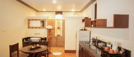 A compact kitchen with a dining area, featuring a sink, stove, and cabinets.