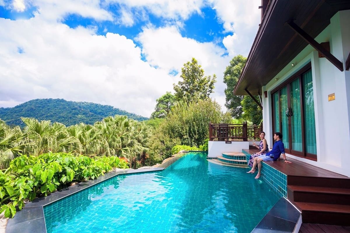 Piscina com vista para uma montanha e vegetação exuberante.