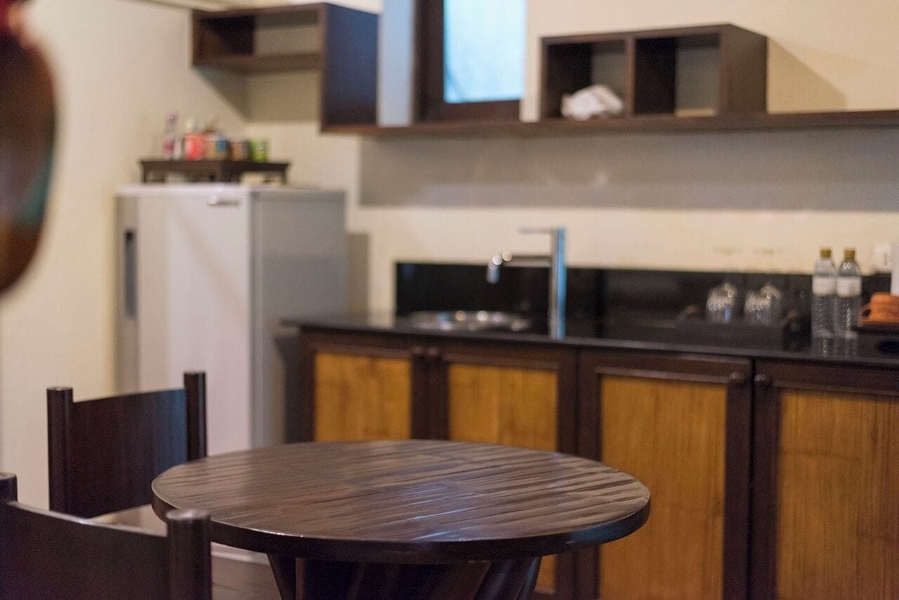 Una cocina con armarios de madera, un refrigerador y un lavamanos.