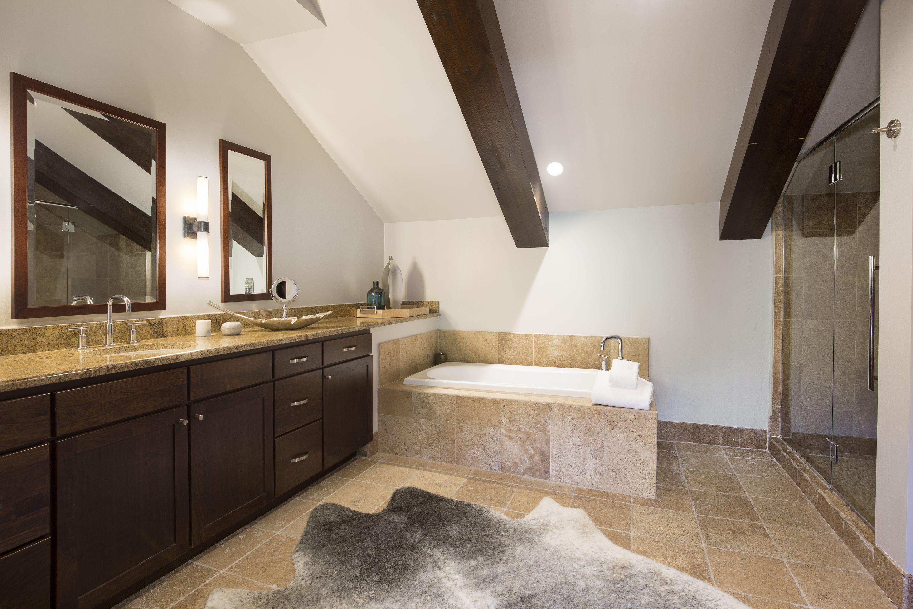 A modern bathroom with a large mirror, a bathtub, and a shower area.