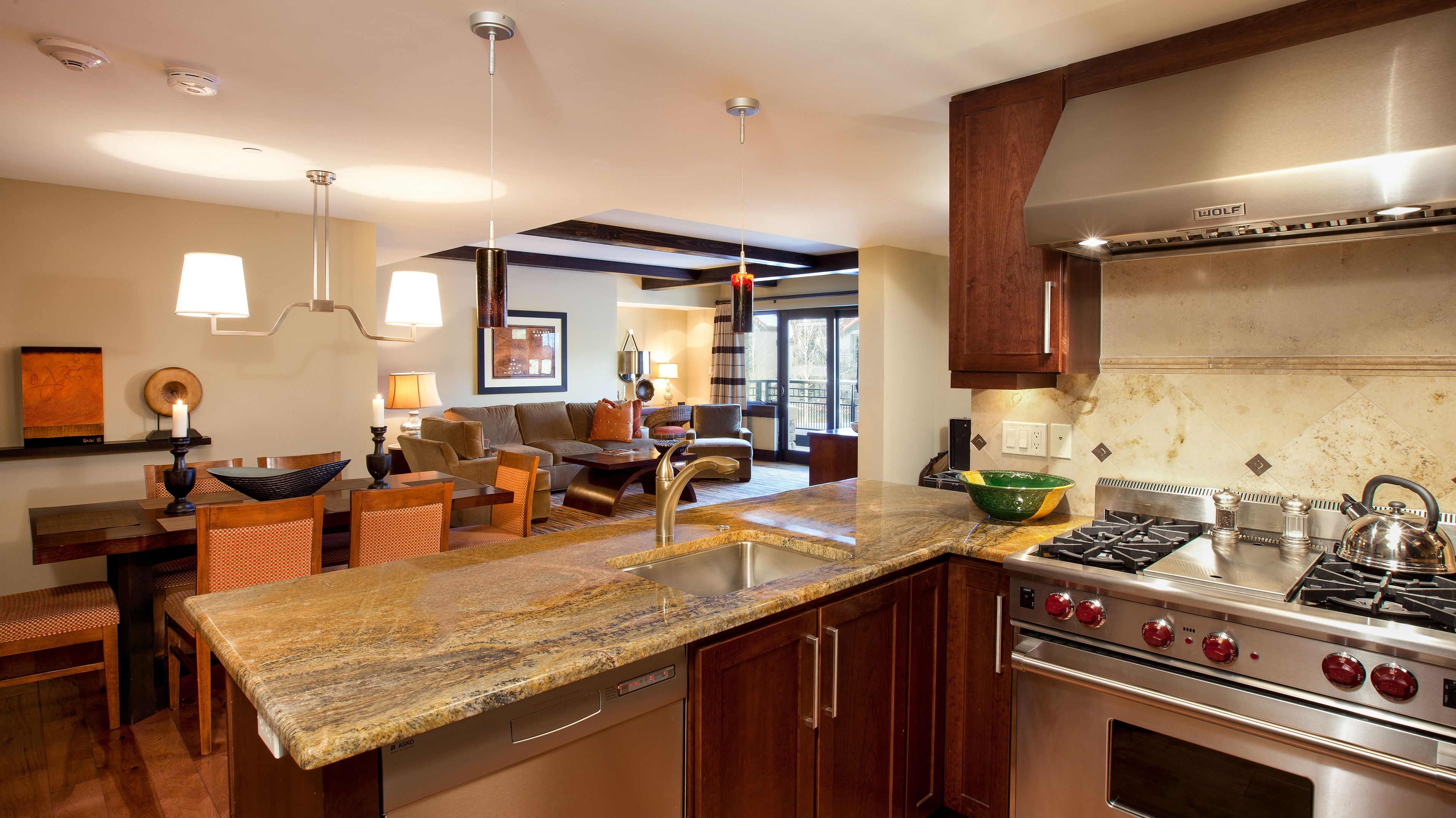 A modern kitchen with granite countertops, stainless steel appliances, and wooden cabinets.