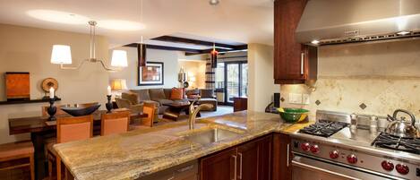 A modern kitchen with granite countertops, stainless steel appliances, and wooden cabinets.