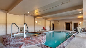Ein Swimmingpool mit einem Ziegel-Whirlpool, einer Liege und einem Schild, das den Poolbereich kennzeichnet.