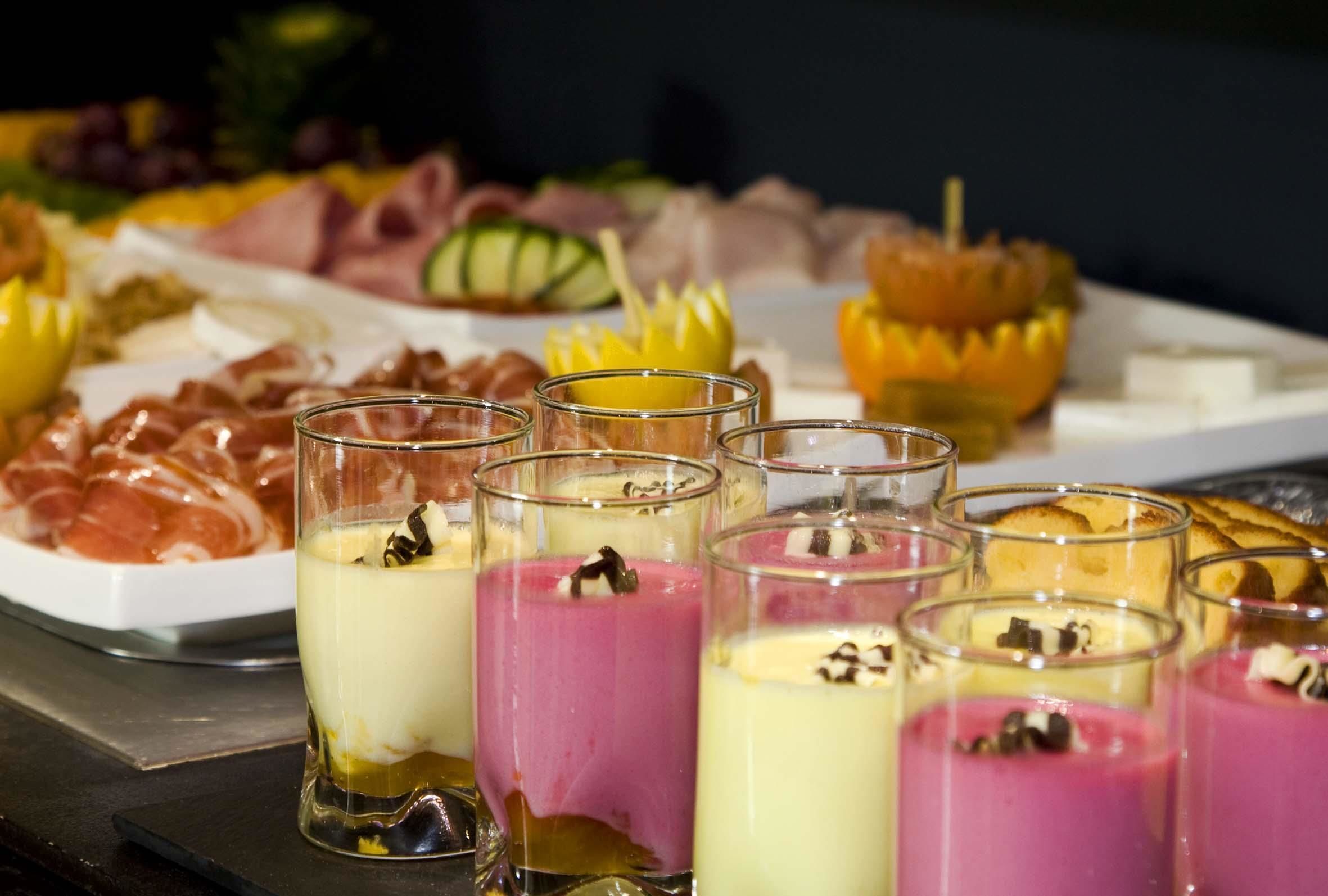 A variety of food items including meats, cheeses, and desserts on a tray.