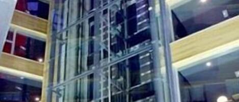 Un edificio de varios pisos con fachada de vidrio y estructura metálica.