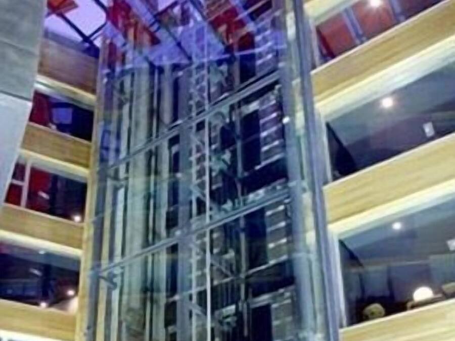 A multi-story building with a glass facade and a metal framework.