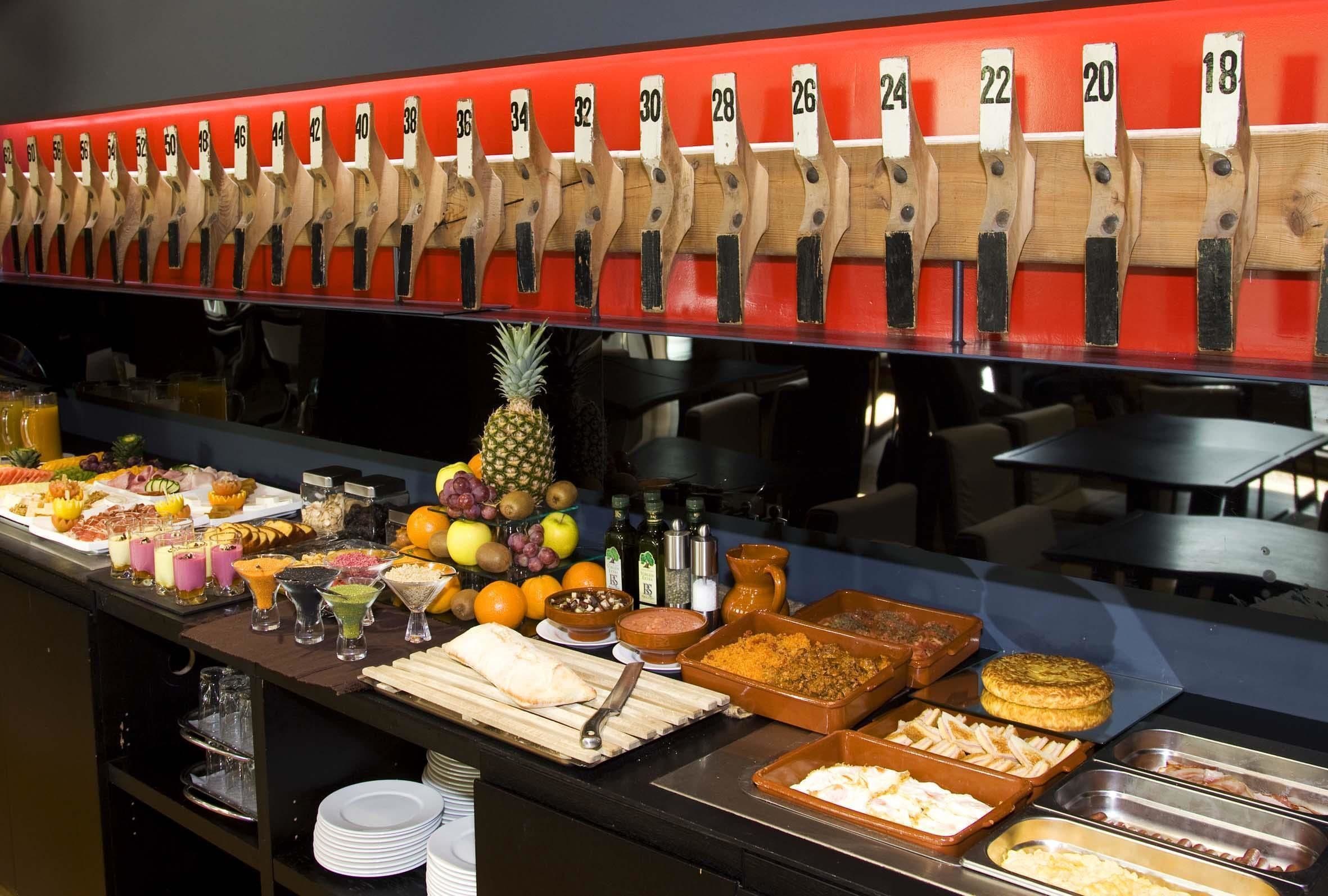 Un bufé con estaciones de servicio numeradas, una variedad de alimentos y una piña como pieza central.