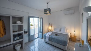 Une chambre d’hôtel moderne équipée d’un lit, d’une armoire, d’une salle de bain et d’un balcon.
