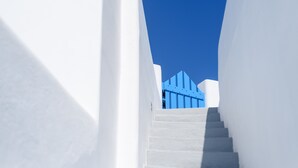 A white staircase leading up to a blue structure against a clear blue sky. - Abyssanto Suites & Spa (Santorini)