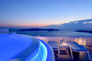 Una piscina al aire libre, sombrillas, sillones reclinables de piscina