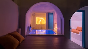 A modern interior with a pool, arched ceilings, and a cozy seating area. - Abyssanto Suites & Spa (Santorini)