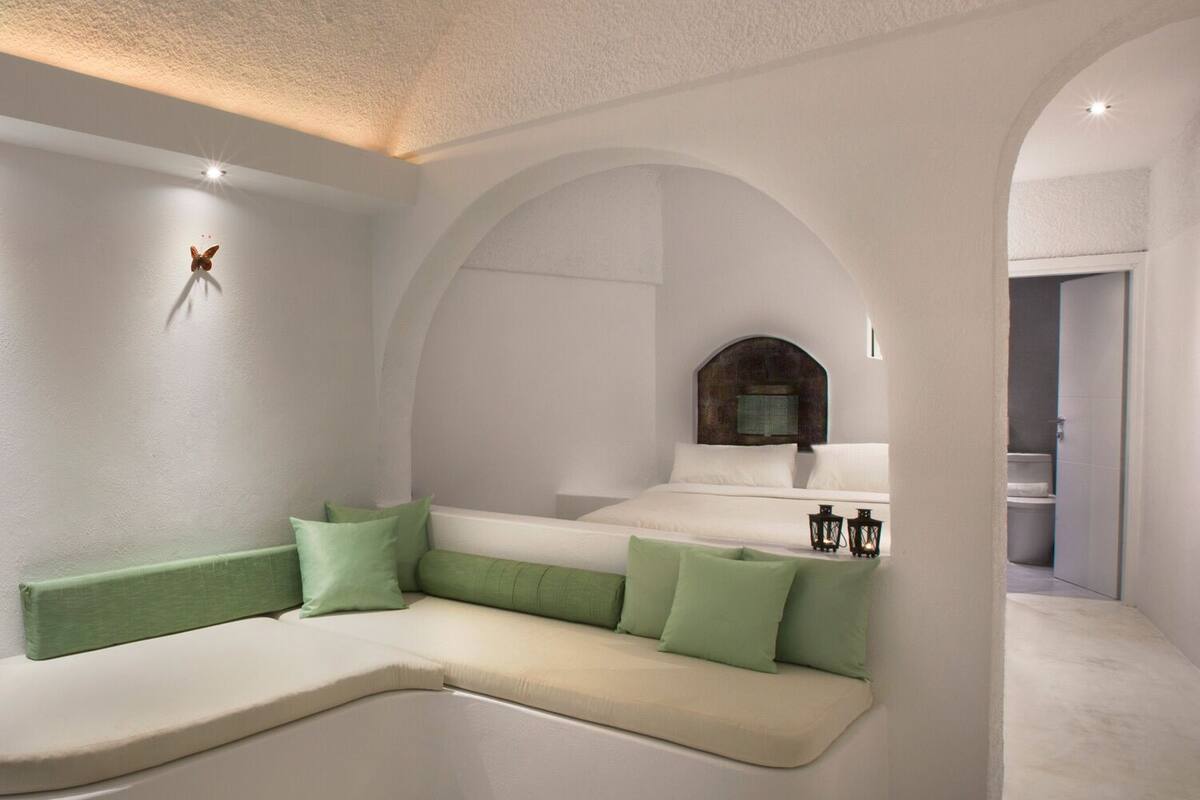 A modern interior with a curved seating area, a decorative butterfly, and a view into a bathroom.