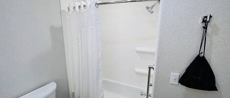 Un baño con inodoro, ducha y bañera.