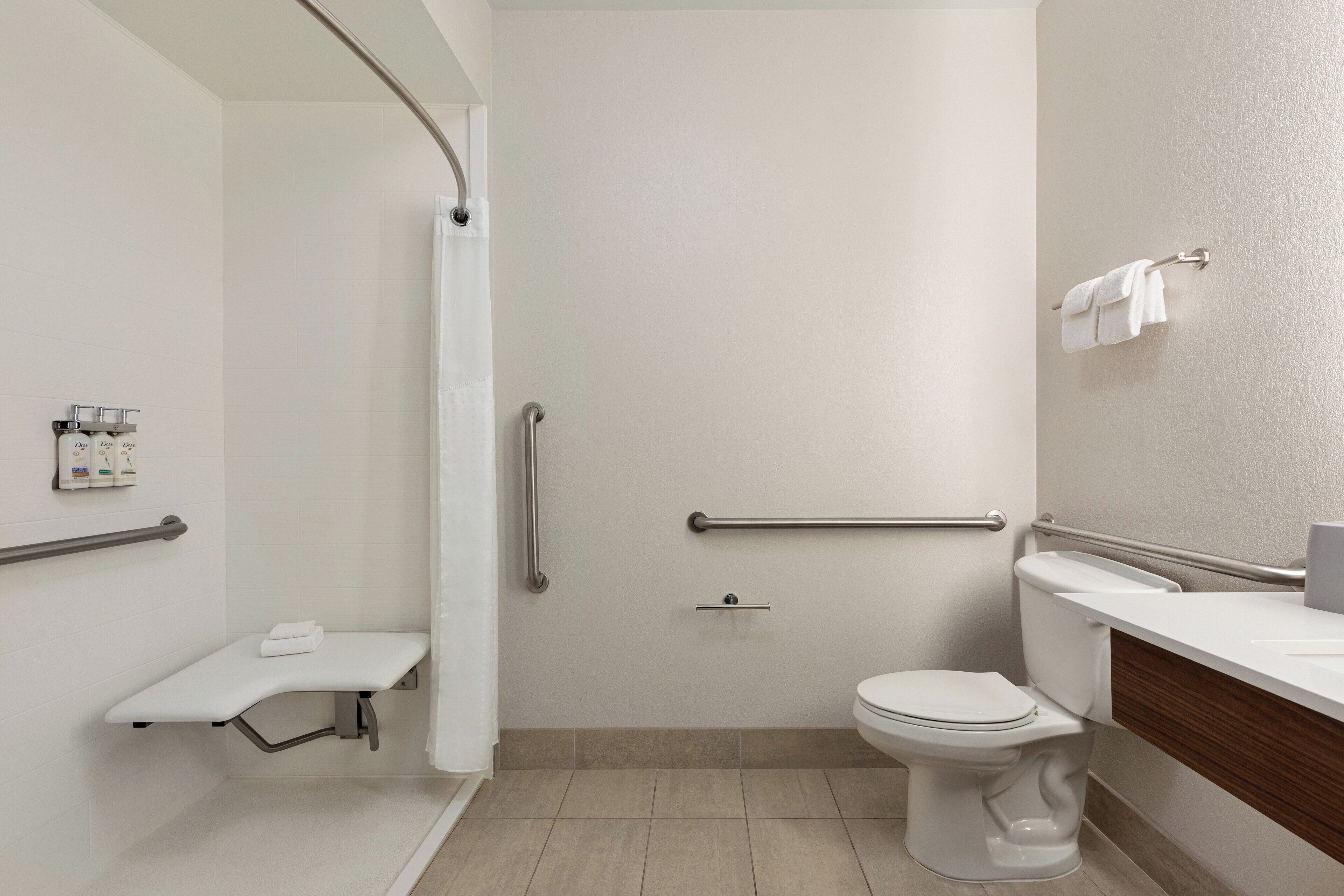 Une salle de bain moderne équipée d’une douche, de toilettes et d’un meuble-lavabo.