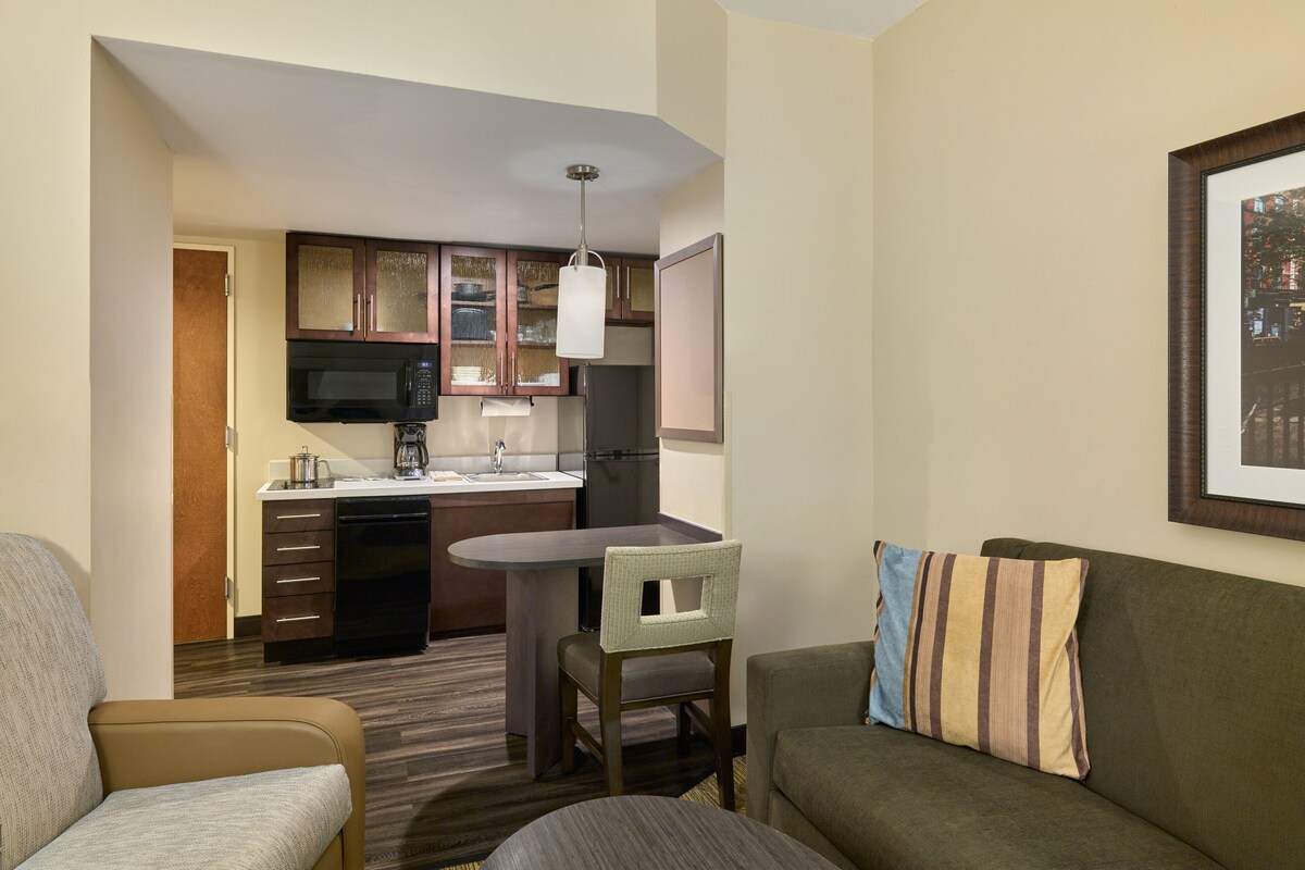 A compact living space with a kitchenette, a dining area, and a seating area.