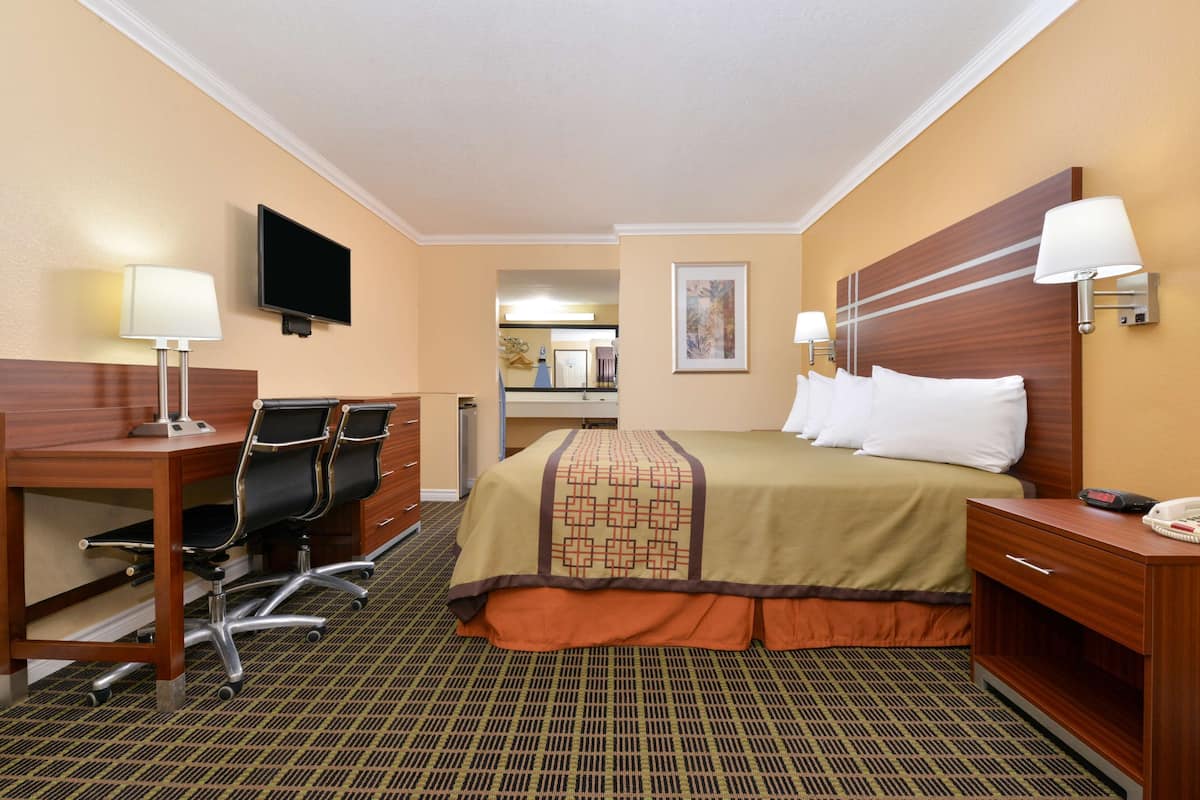 Une chambre d’hôtel équipée d’un lit, d’un bureau, d’une chaise et d’un téléviseur.