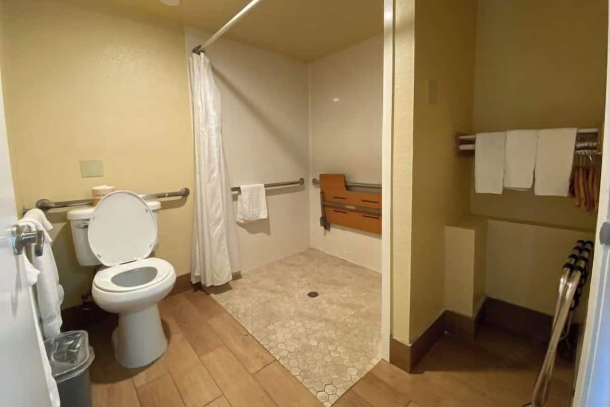 Une petite salle de bain comprenant des toilettes, une douche et un porte-serviettes.