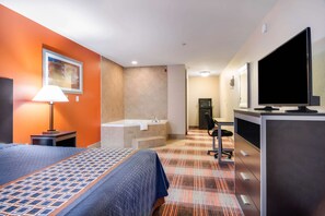 A hotel room with a bed, a desk, a television, a bathroom with a bathtub, and a painting on the wall.