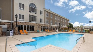 A swimming pool with lounge chairs, a building with multiple windows, and a clear sky. - Holiday Inn Express Hotel & Suites New Iberia - Avery Island by IHG (New Iberia)
