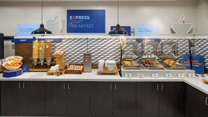 Un bufé de desayuno con secciones identificadas para fruta, cereales y comida caliente.