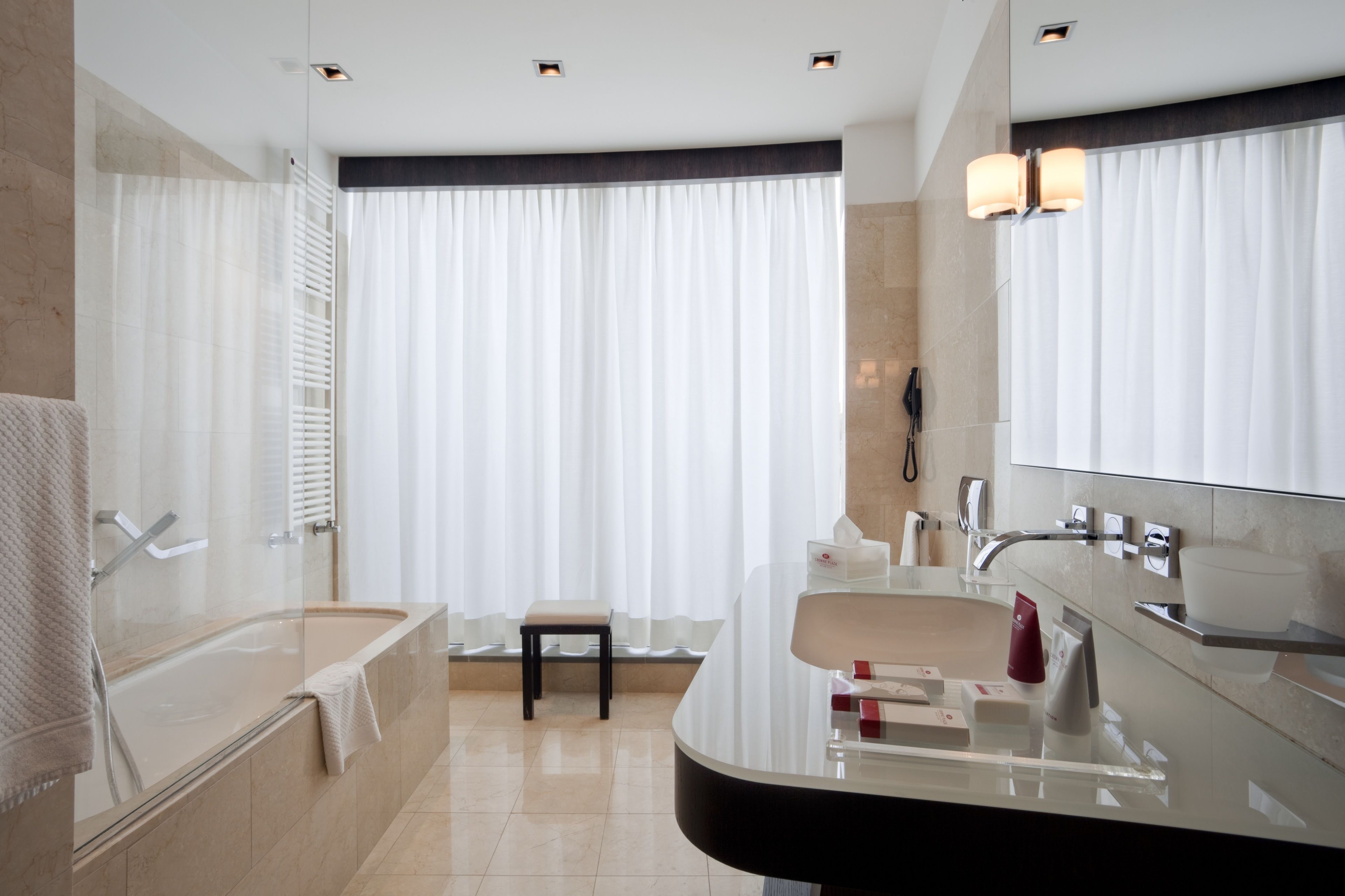 A modern bathroom with a bathtub, a vanity with a mirror, and a shower area.