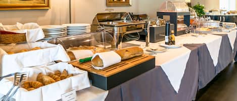 A buffet setup with various food items and a sign indicating 'Brochettes & Croissants'.