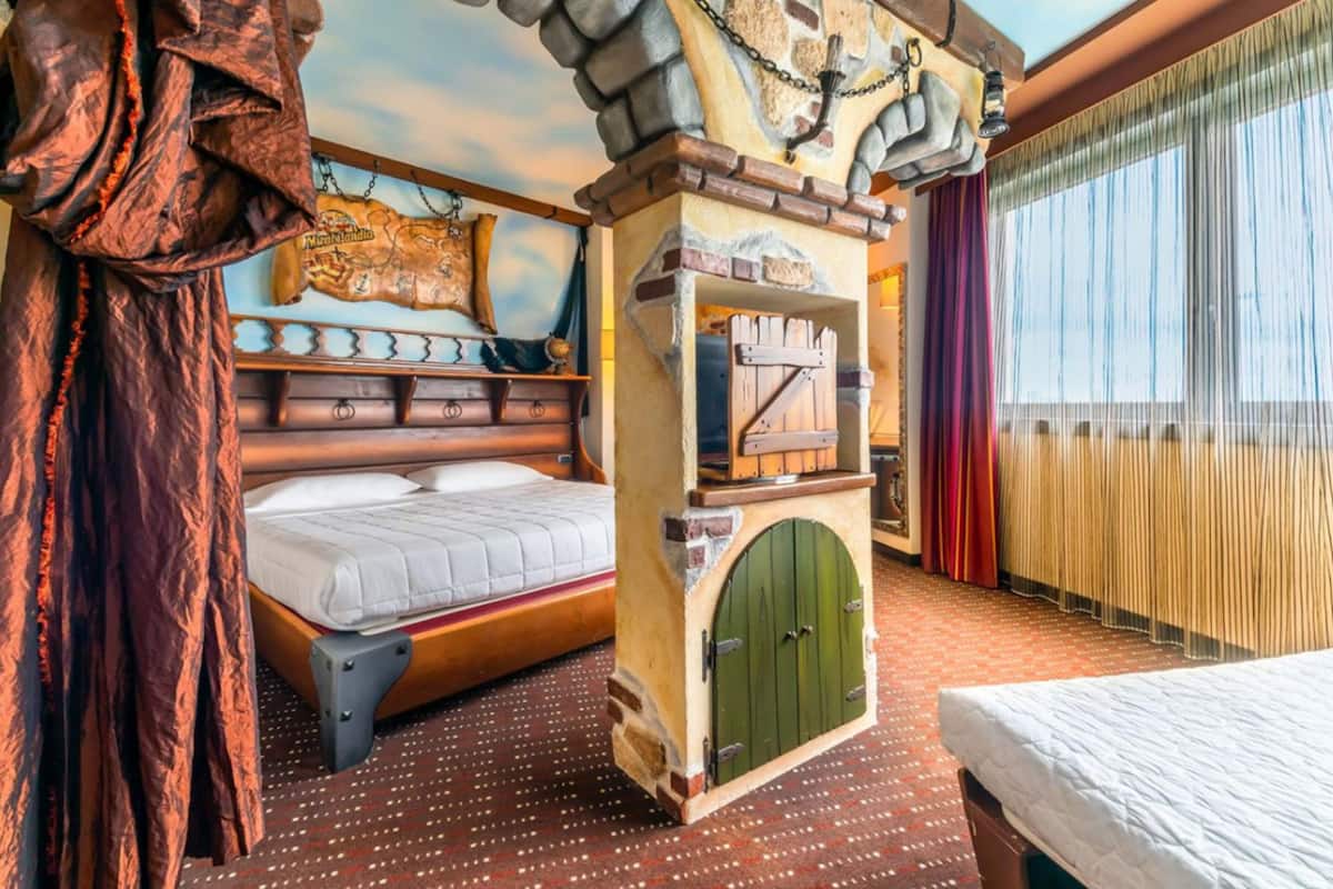 Un dormitorio con cama, armario, una puerta verde y un mapa en la pared.