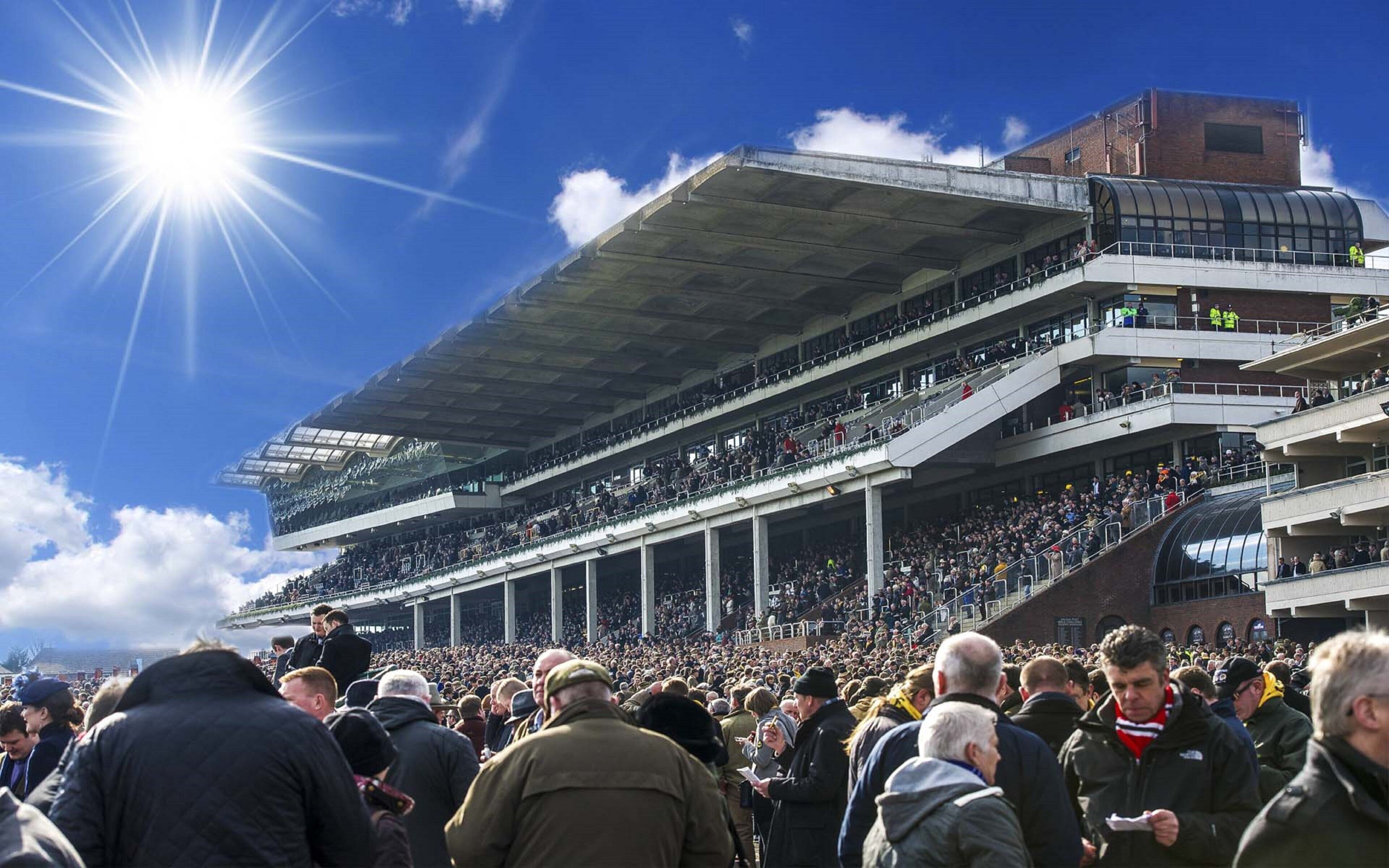 A stadium with multiple tiers of seating and a large crowd gathered outside.