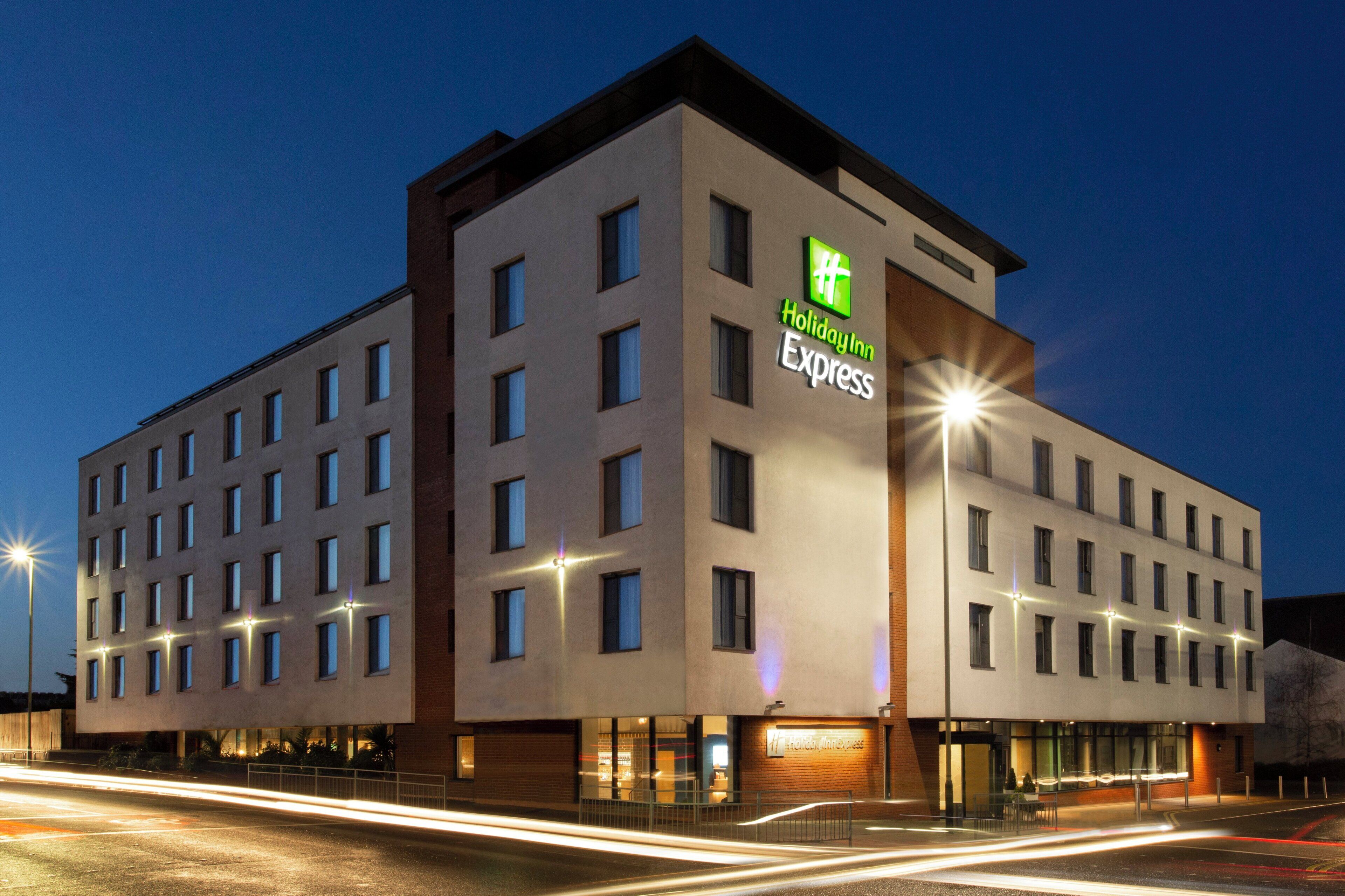 A Holiday Inn Express hotel with a modern design, featuring multiple floors and a prominent signage.