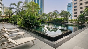 A rooftop pool area with lounge chairs, a small pool, and surrounding greenery. - Grande Centre Point Ratchadamri (Bangkok)