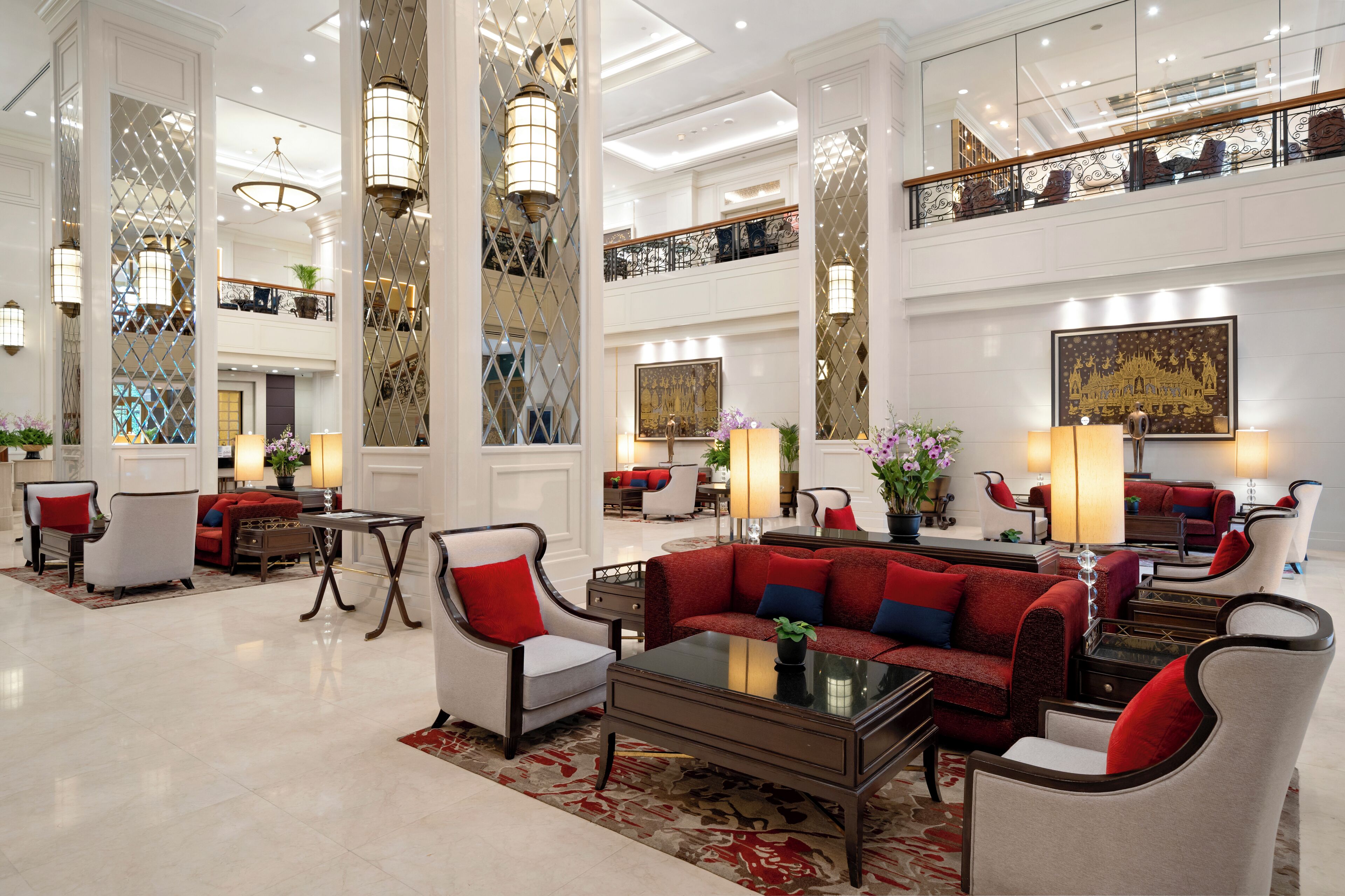 A spacious lobby with high ceilings, elegant furniture, and large windows.