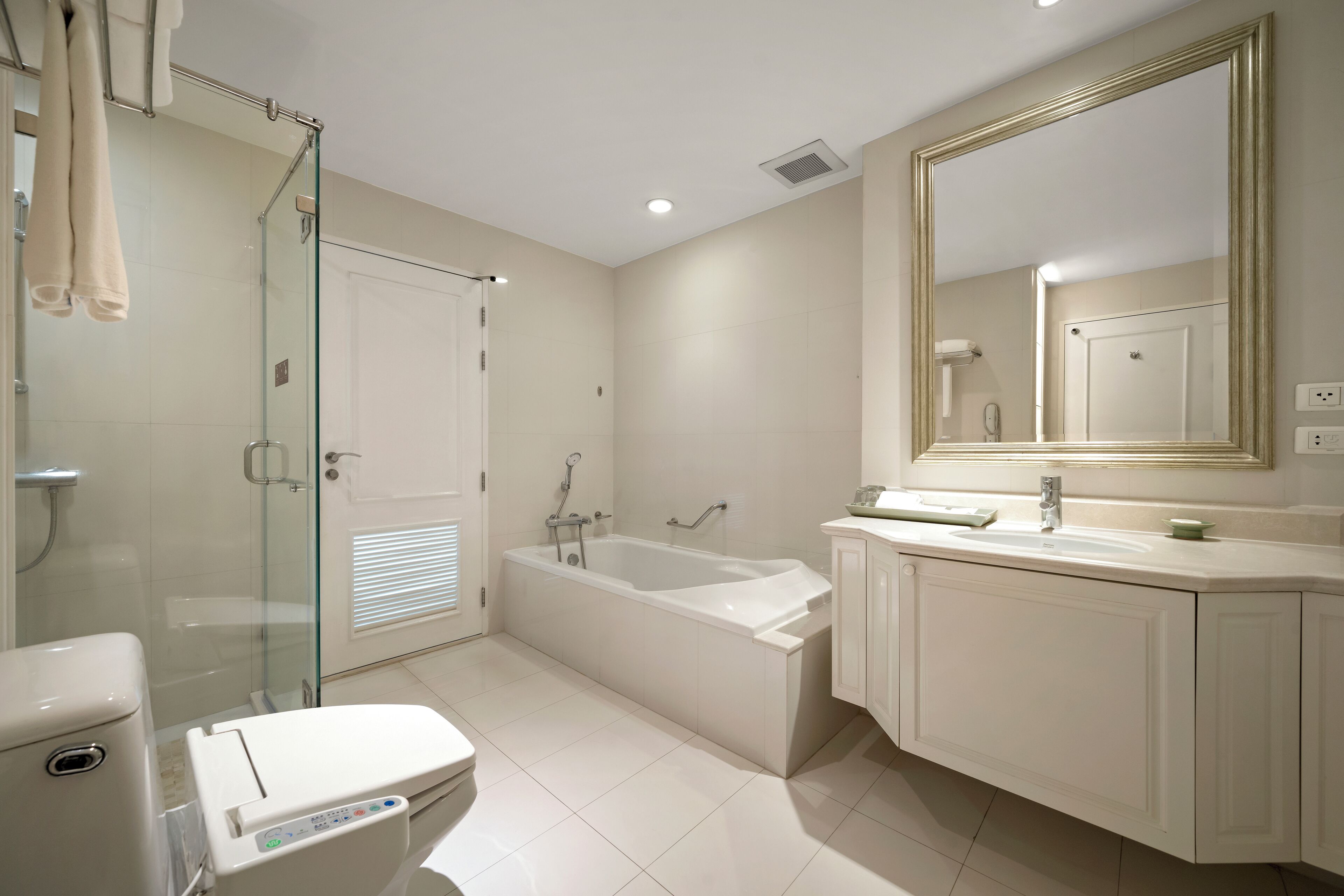 A modern bathroom with a glass-enclosed shower, a freestanding bathtub, and a vanity with a mirror.