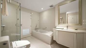 A modern bathroom with a glass-enclosed shower, a freestanding bathtub, and a vanity with a mirror.