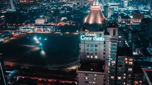 A nighttime cityscape with a prominent building labeled "Grande Centre Point."