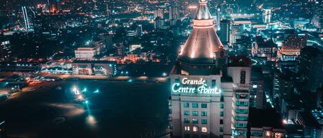 Un paisaje urbano nocturno con un edificio destacado marcado como "Grande Centre Point".