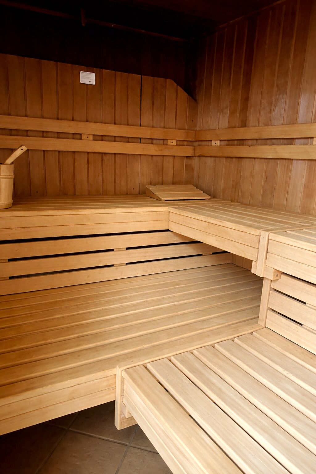 Uma sauna com bancos de madeira e piso de madeira.