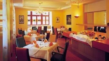 A restaurant with round tables, chairs, and a bar area.