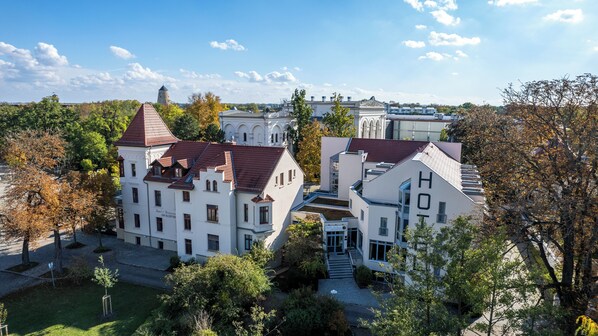 A large, historic building with multiple wings and a central courtyard. - Hotel Am Kurpark Bad Salzelmen (Schönebeck)