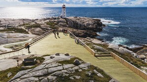 A coastal walkway leading to a lighthouse, surrounded by rocky terrain and the ocean. - Holiday Inn Express & Suites Halifax Airport by IHG (Goffs)