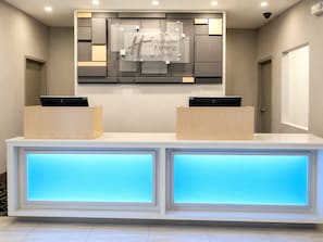 A reception desk with a modern design, featuring a logo for Holiday Inn Express & Suites. - Holiday Inn Express & Suites Halifax Airport by IHG (Goffs)
