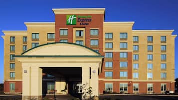 Un hôtel Holiday Inn Express & Suites avec une façade en briques, de nombreuses fenêtres et une entrée centrale.