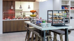 Une cuisine moderne dotée d’un îlot central, de tabourets de bar et d’une variété de produits alimentaires exposés.