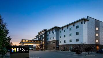 A multi-story hotel with a modern design, featuring a prominent entrance and a signboard.