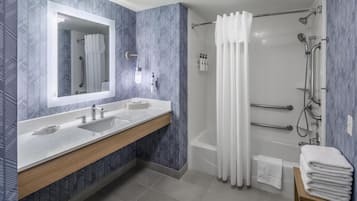 Een moderne badkamer met twee wastafels, een douche en een grote spiegel.