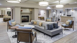 A modern hotel lobby with a fireplace, seating area, and a reception desk. - Homewood Suites by Hilton Denver Tech Center (Englewood)